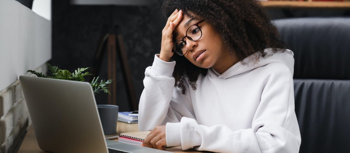 Student using laptop, having headache after hard-working day of e-learning, failed exam test